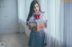 A woman in a school uniform reading a book.