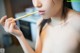 A naked woman holding a chopstick in her mouth.