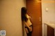 A woman in lingerie leaning against a door in a bathroom.