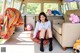 A woman sitting on the floor of a van with stuffed animals.