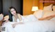 A woman laying on top of a bed in a white dress.