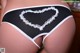 A woman wearing a black and white panties with a heart on it.