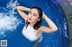 A woman in a white bathing suit standing in a pool.