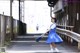 A woman in a blue dress is walking down the street.