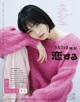 A woman in a pink sweater is posing for a magazine.