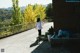 A woman walking down a sidewalk next to a brick building.