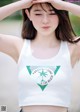 A woman wearing a white crop top with a palm tree on it.