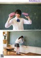 A girl in a school uniform holding a chalkboard in front of her.