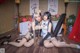 A couple of women sitting on top of a wooden floor.