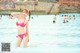 A woman in a pink bikini standing in a pool.