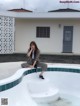 A woman sitting on the edge of a swimming pool.