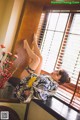 A woman in a kimono leaning against a window sill.