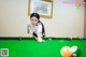 A woman is playing a game of pool. 